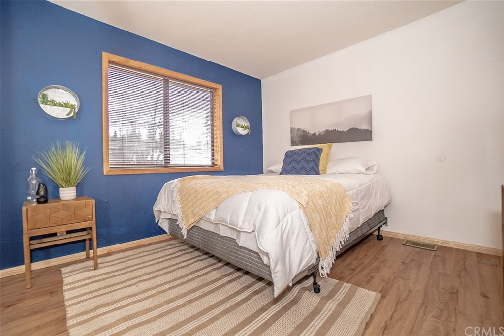 725 Temple Lane Big Bear Lake, CA 92315 - Photo 47 of 65 a bedroom with a bed lamp and a large window with wooden floor