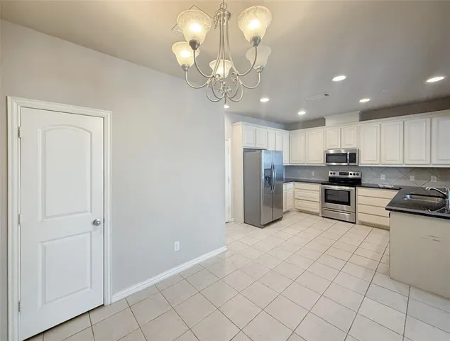 a kitchen with stainless steel appliances granite countertop a refrigerator stove top oven and sink