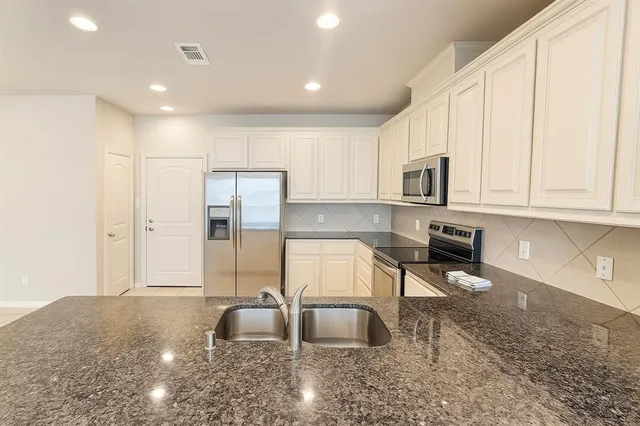 a kitchen with stainless steel appliances granite countertop a refrigerator sink and cabinets