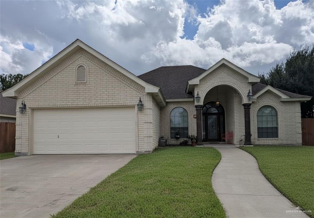 View of front facade with concrete driveway, an attached garage, and brick siding