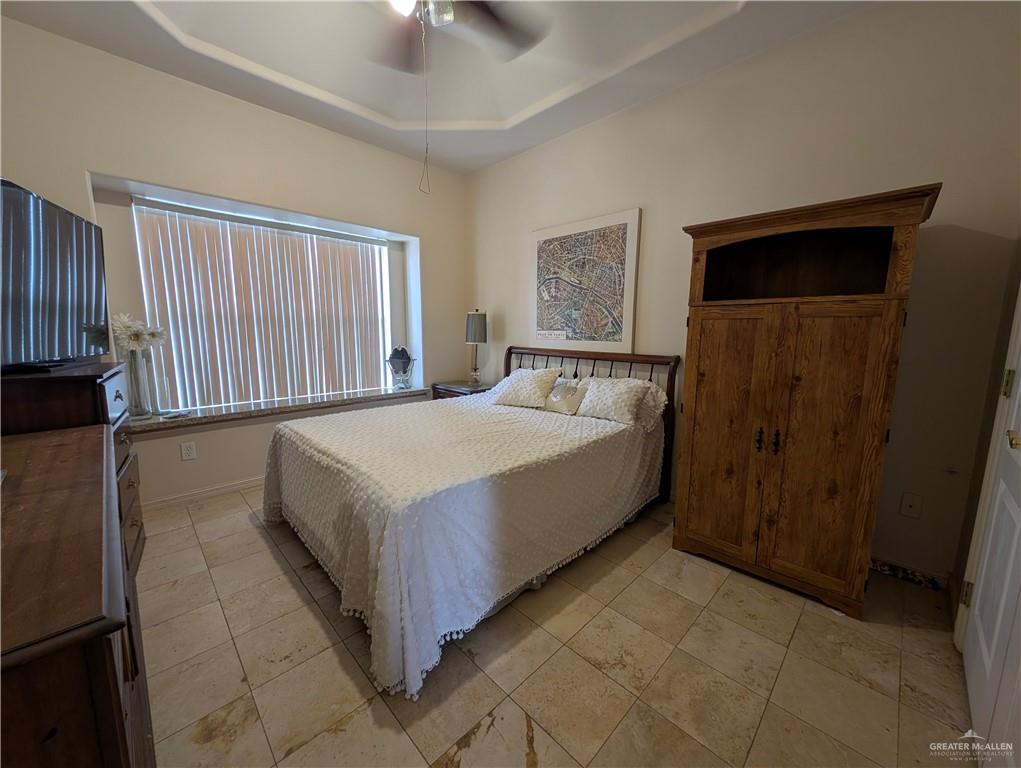 2000 East 25th Street Mission, TX 78574 - Photo 11 of 27 Bedroom featuring a tray ceiling, ceiling fan, and light tile patterned floors