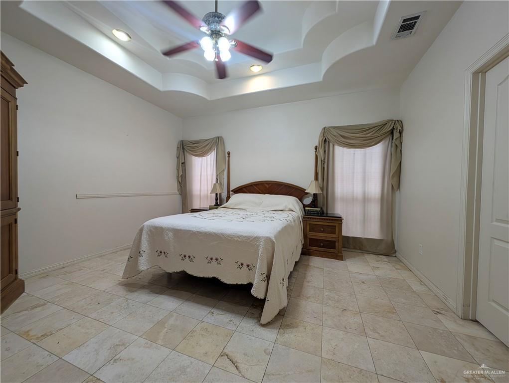 2000 East 25th Street Mission, TX 78574 - Photo 13 of 27 Bedroom featuring a tray ceiling and ceiling fan