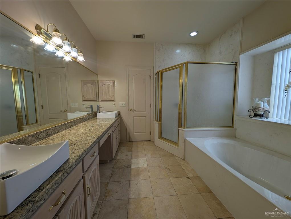 2000 East 25th Street Mission, TX 78574 - Photo 14 of 27 Full bath featuring double vanity, a shower stall, a bath, and light tile patterned floors