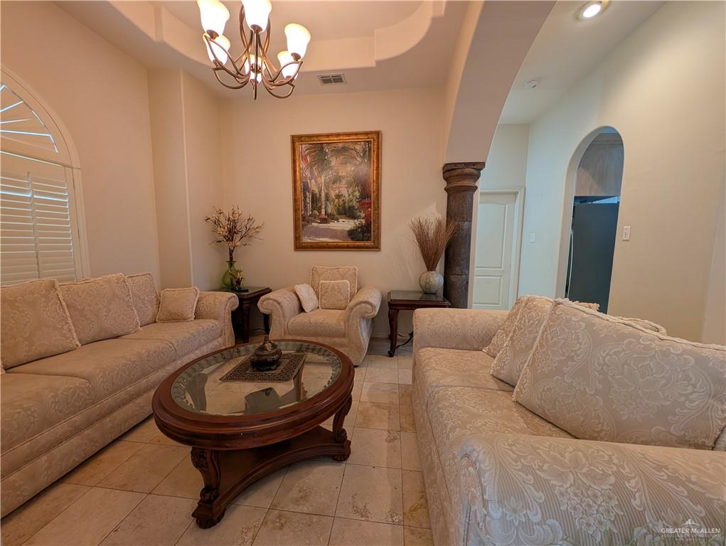 2000 East 25th Street Mission, TX 78574 - Photo 4 of 27 Tiled living area featuring arched walkways, a raised ceiling, and a chandelier