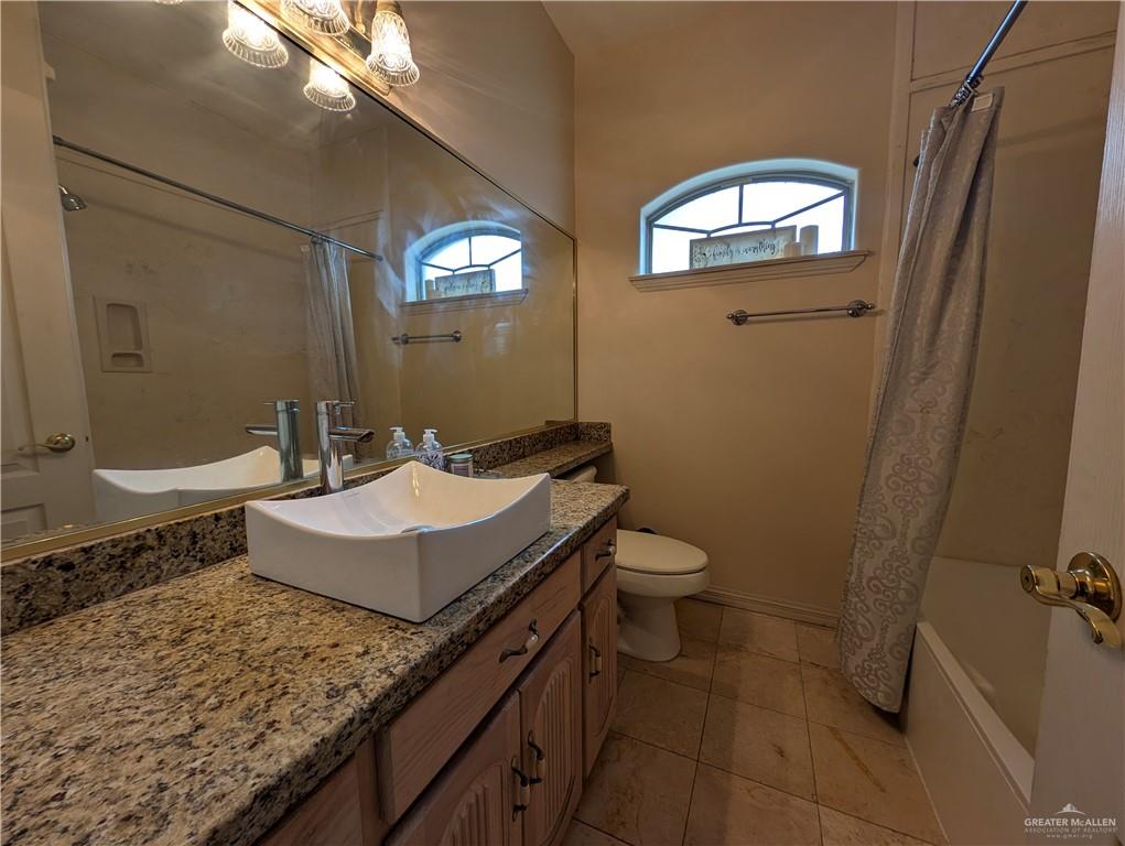 2000 East 25th Street Mission, TX 78574 - Photo 7 of 27 Bathroom featuring shower / bath combo with shower curtain, vanity, and light tile patterned flooring