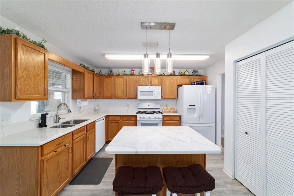 9662 Southwest 97th Lane Ocala, FL 34481 - Photo 24 of 52 a kitchen with kitchen island a stove a sink a refrigerator and cabinets