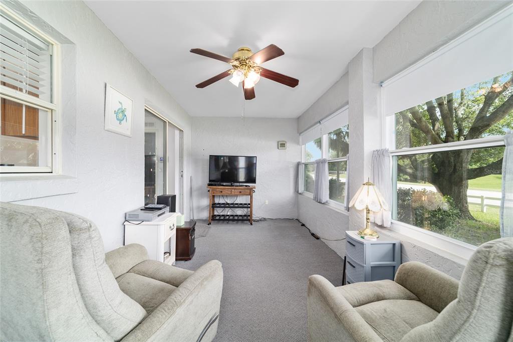 9662 Southwest 97th Lane Ocala, FL 34481 - Photo 46 of 52 a living room with furniture a ceiling fan and a large window