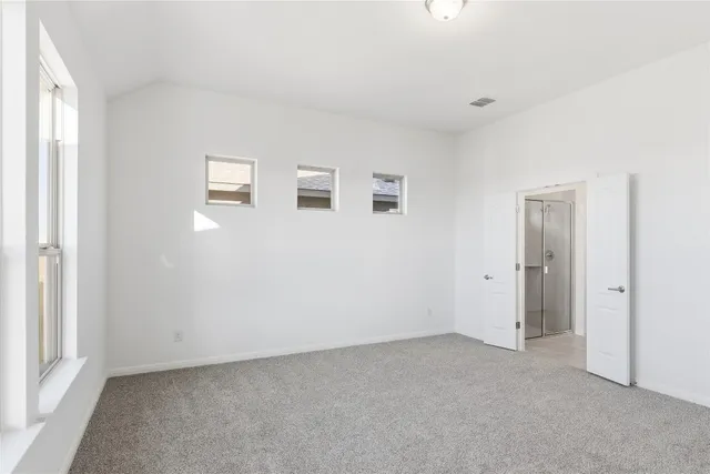 an empty room with wooden floor cabinet and windows