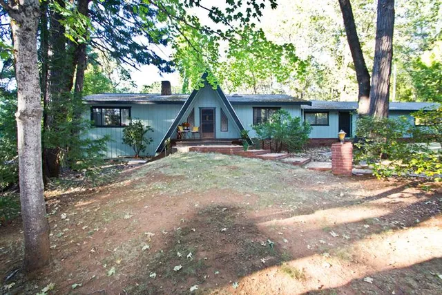 a view of a house with a tree beside of it