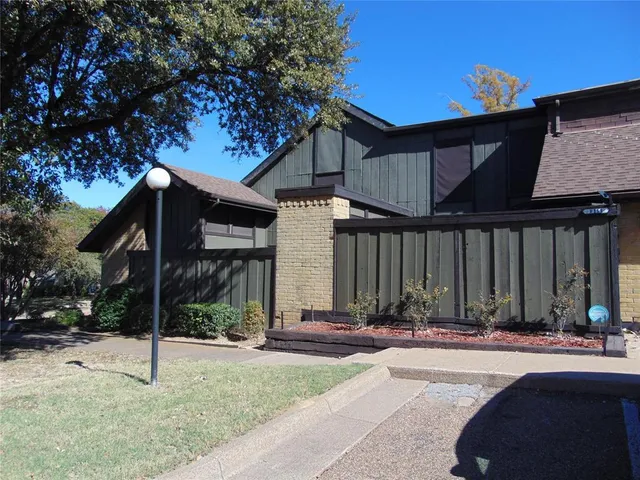 a view of a house with a small yard and tree s