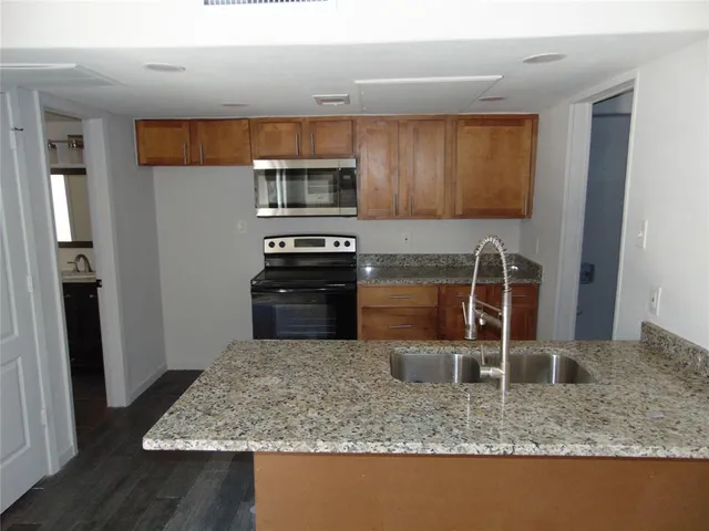 a kitchen with stainless steel appliances granite countertop a sink stove and refrigerator
