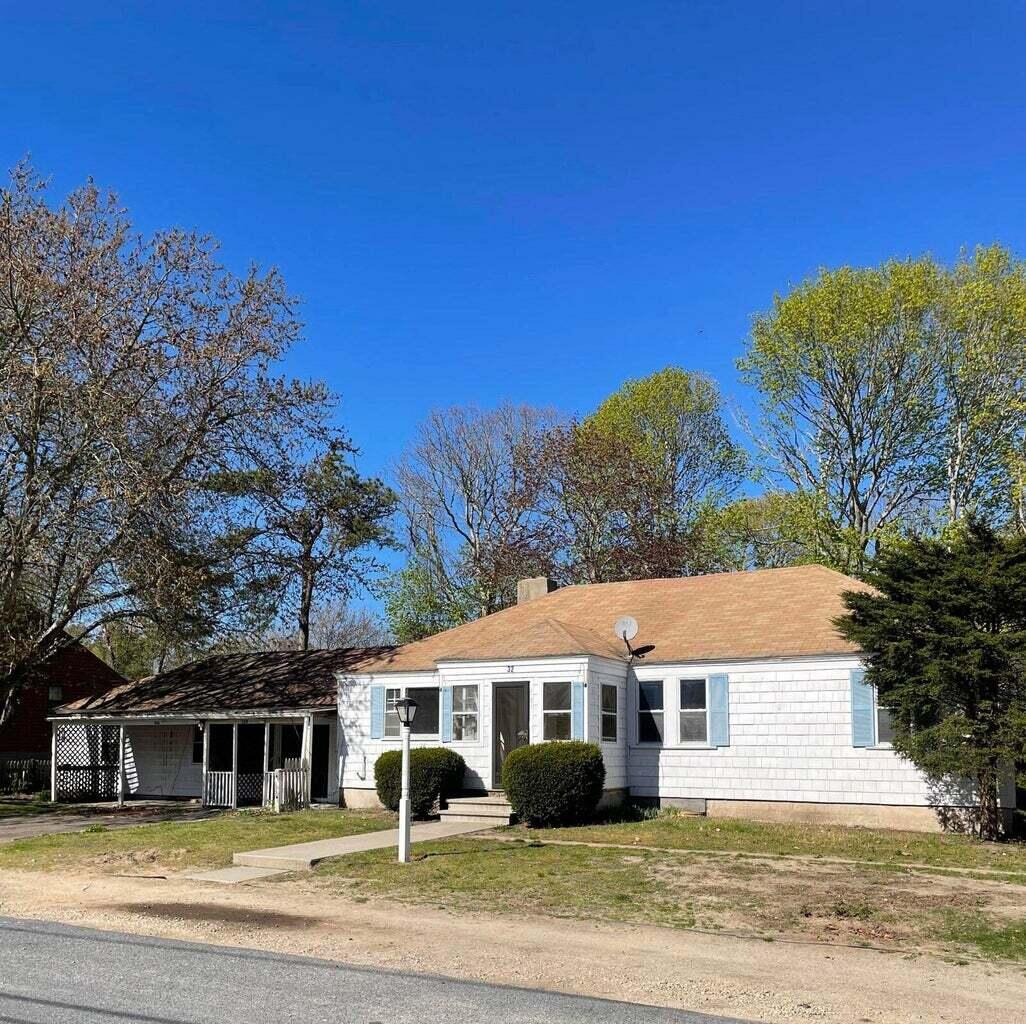 a front view of a house with a garden and yard