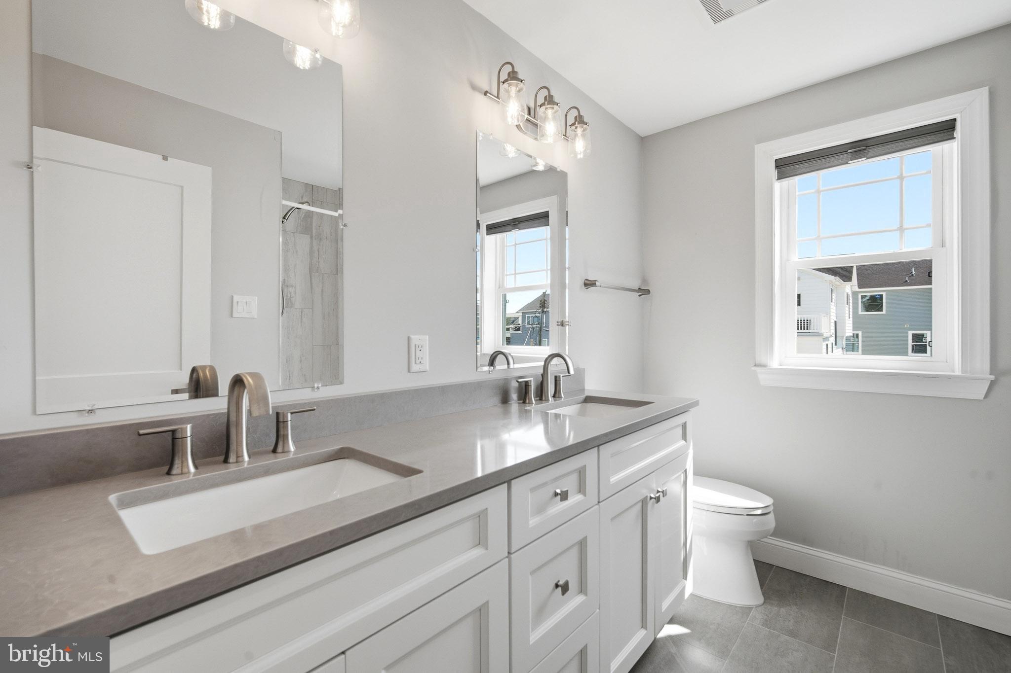 2500 Bayshore Avenue Brigantine, NJ 08203 - Photo 16 of 62 a bathroom with double vanity a toilet a and a window