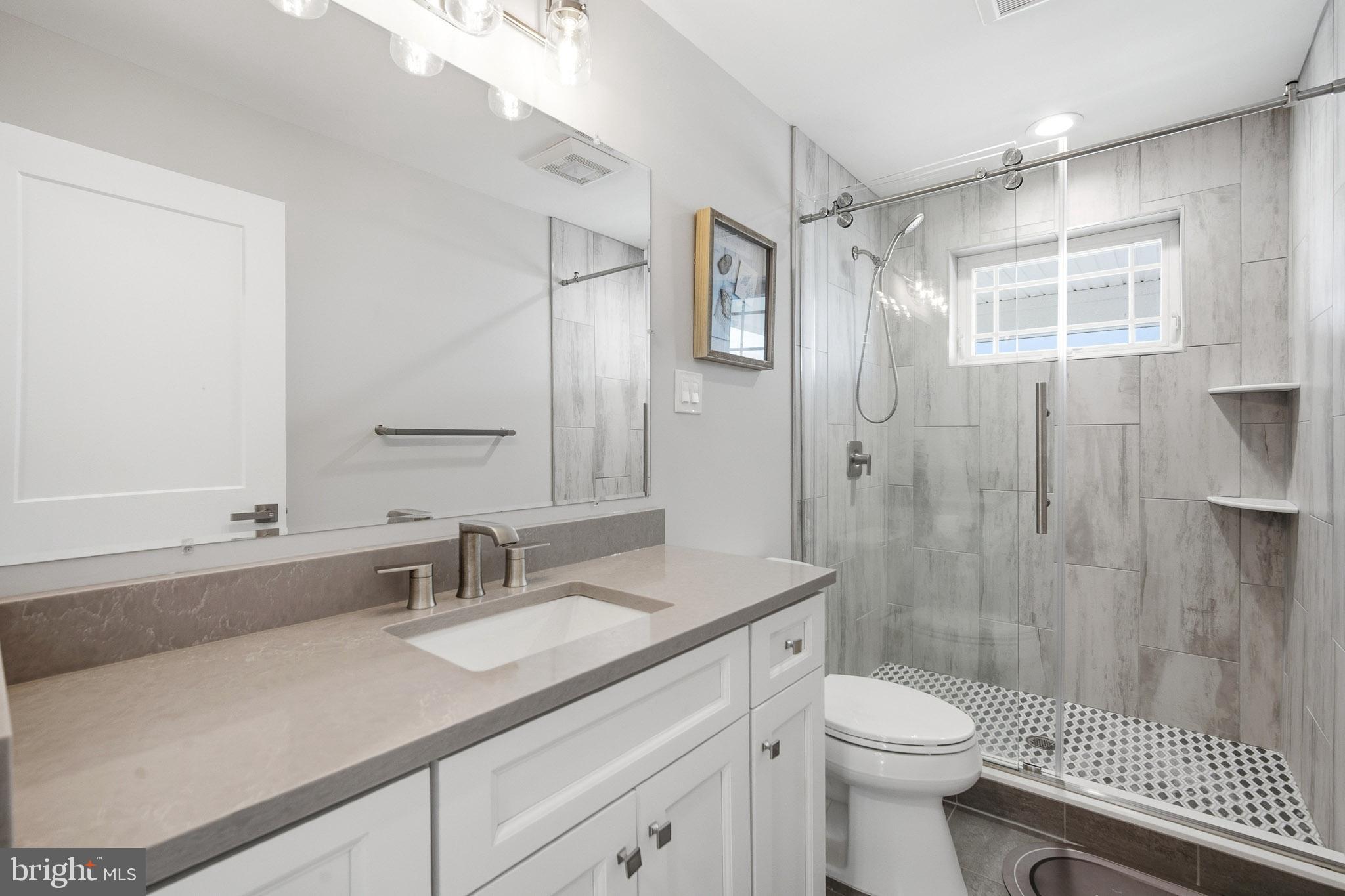2500 Bayshore Avenue Brigantine, NJ 08203 - Photo 20 of 62 a bathroom with a sink a toilet a mirror and shower