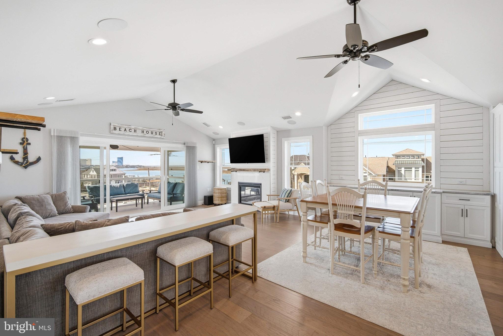 2500 Bayshore Avenue Brigantine, NJ 08203 - Photo 26 of 62 a dining room with wooden floor a chandelier fan a wooden table and chairs