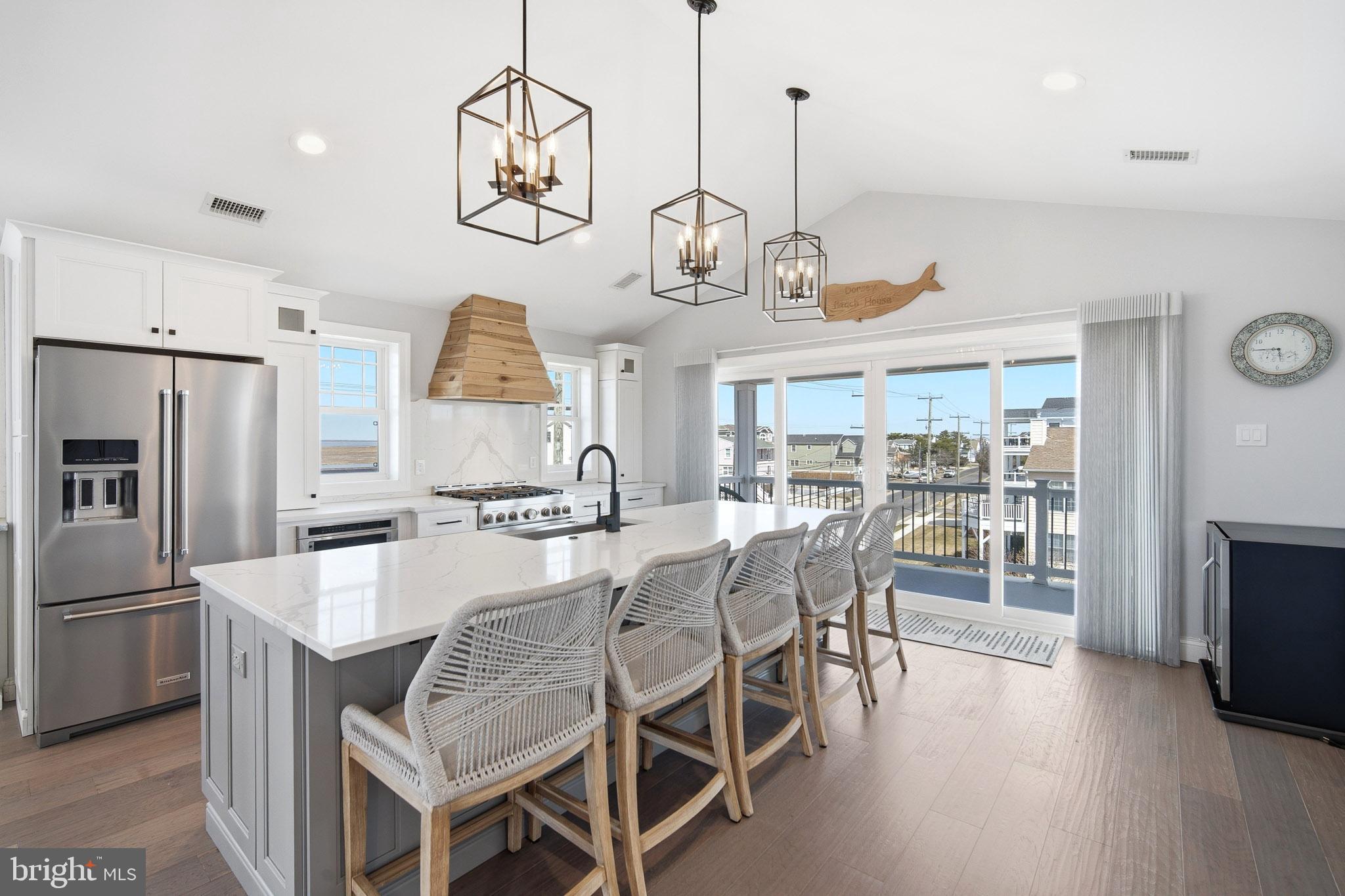 2500 Bayshore Avenue Brigantine, NJ 08203 - Photo 30 of 62 a kitchen with stainless steel appliances granite countertop a table chairs in it and wooden floors