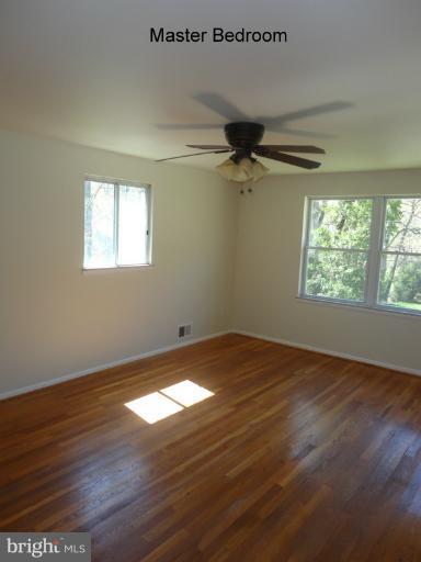 12803 Broadmore Road Silver Spring, MD 20904 - Photo 7 of 11 an empty room with wooden floor fan and windows