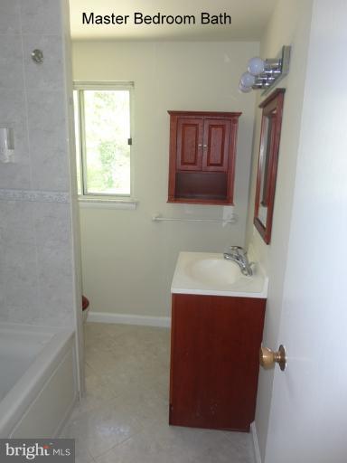 12803 Broadmore Road Silver Spring, MD 20904 - Photo 10 of 11 a bathroom with a granite countertop sink and a mirror