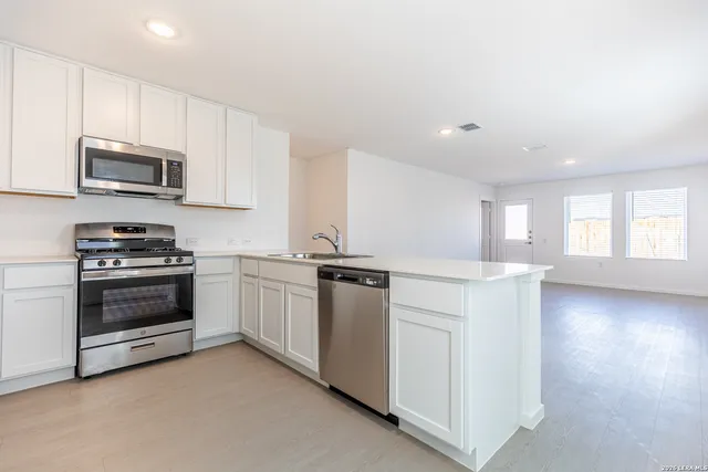 a kitchen with stainless steel appliances a stove a microwave sink and cabinets