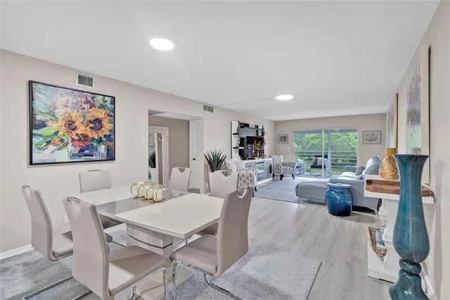 a living room with furniture a large window and kitchen view