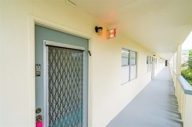 a hallway with wooden floor windows and closet