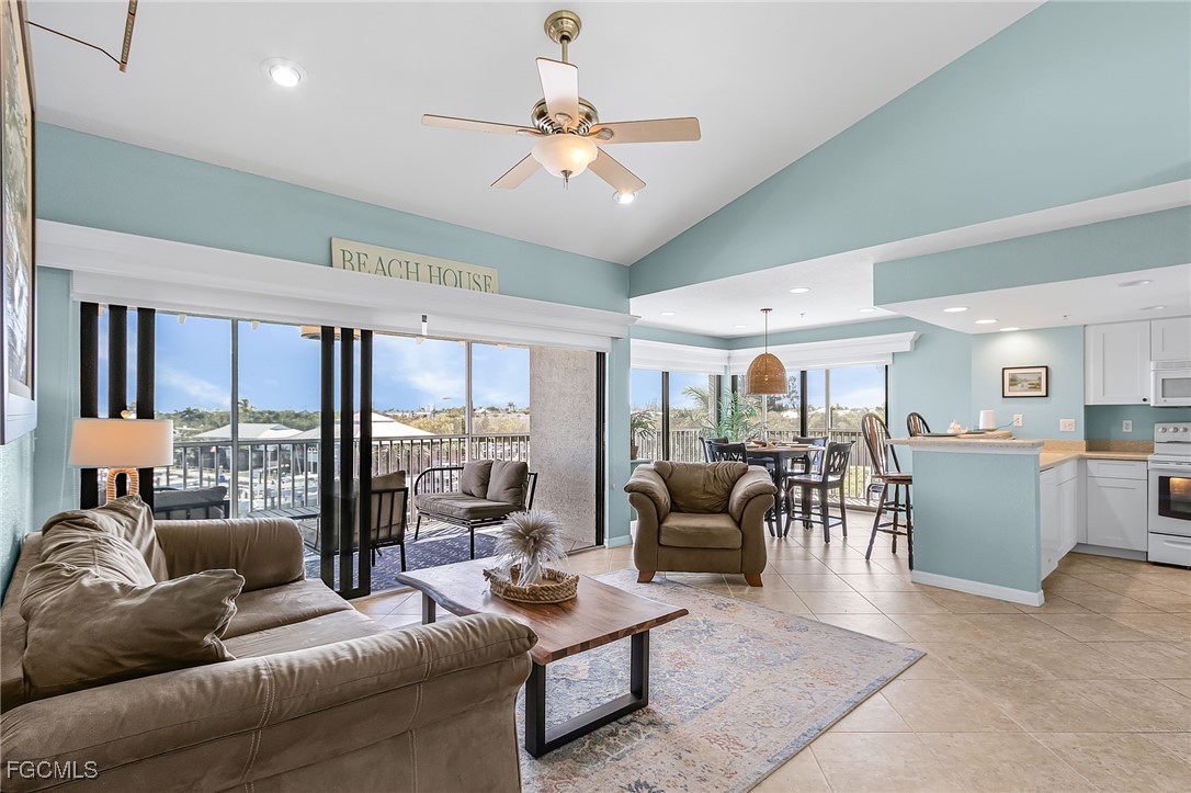 16641 Stringfellow Road, Unit 506 Bokeelia, FL 33922 - Photo 5 of 43 a living room with furniture a ceiling fan and a large window