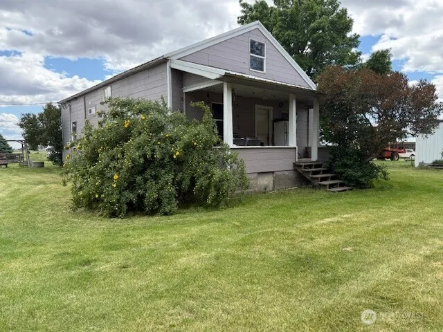 a view of a house with backyard and trees