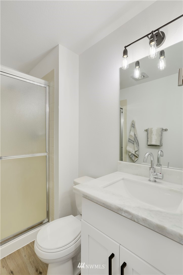 4114 Northeast 5th Street Renton, WA 98059 - Photo 13 of 20 a bathroom with a sink a toilet a mirror and shower