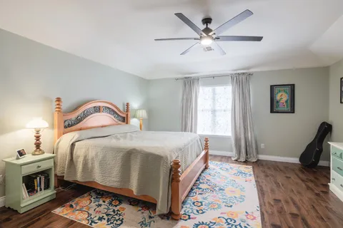 a bedroom with bed and wooden floor