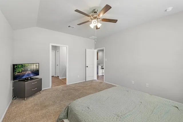 a bedroom with a large bed and a chandelier