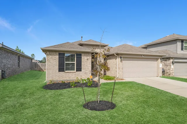 a front view of a house with a garden and plants