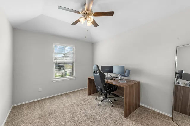 a view of a workspace with furniture and a window