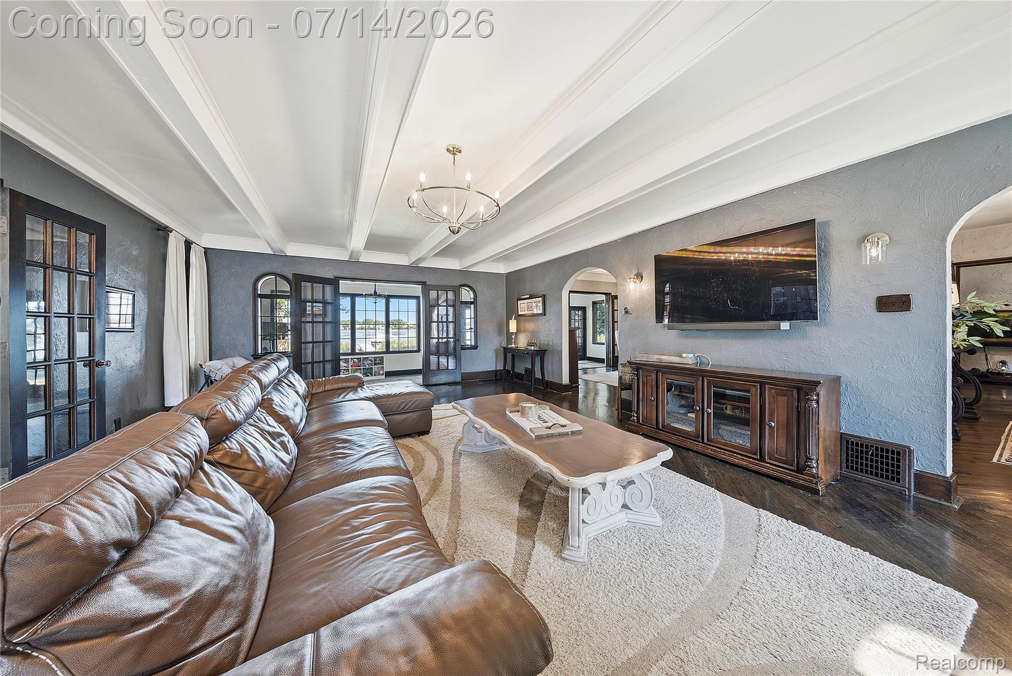 18460 Meridian Road Grosse Ile, MI 48138 - Photo 8 of 50 Spacious living area featuring exposed beam ceilings, dark wood-finish flooring, multiple sets of French doors, and archways