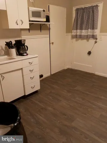 a kitchen with cabinets and a wooden floor