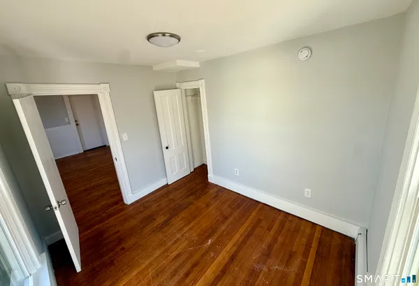 a view of a hallway with wooden floor and stairs