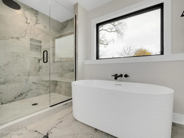 a white bath tub sitting next to a shower
