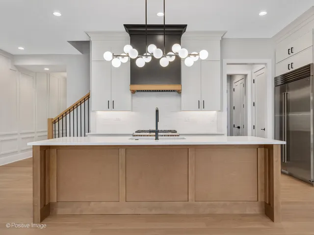 a kitchen with cabinets a sink dishwasher and a refrigerator with wooden floor
