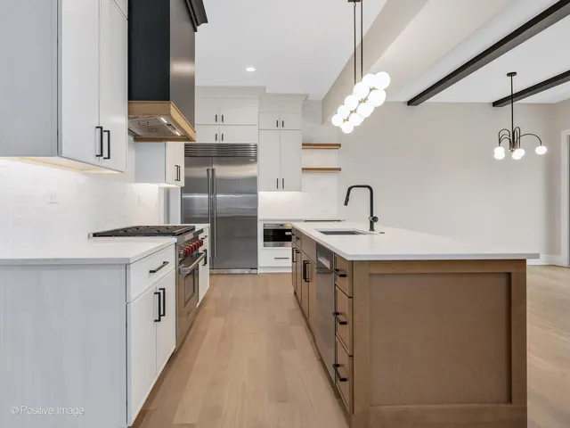 a kitchen with stainless steel appliances granite countertop a sink a stove and a refrigerator