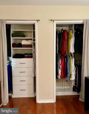 a view of walk in closet with clothes and shoes