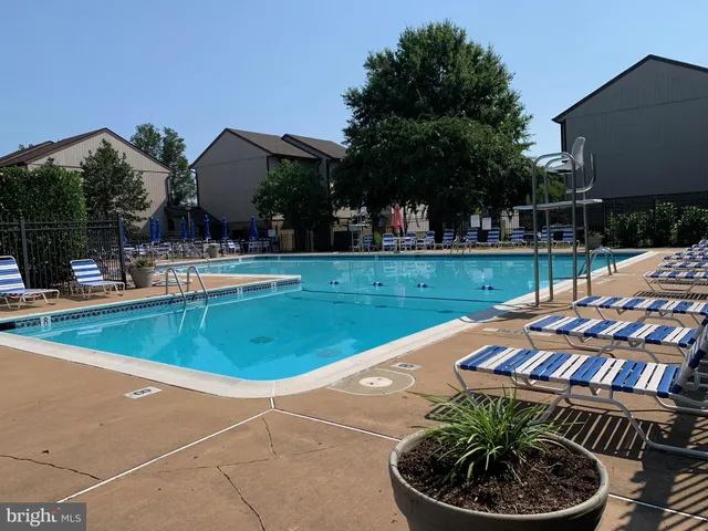 a view of a backyard with swimming pool and outdoor seating