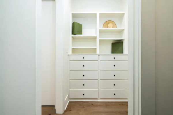 a view of an empty walk in closet with wooden floor