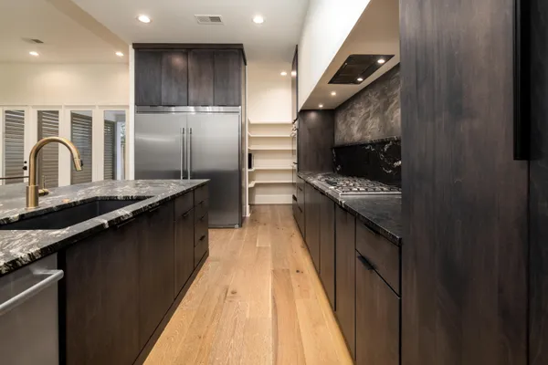 a kitchen with stainless steel appliances granite countertop a stove a sink and a refrigerator