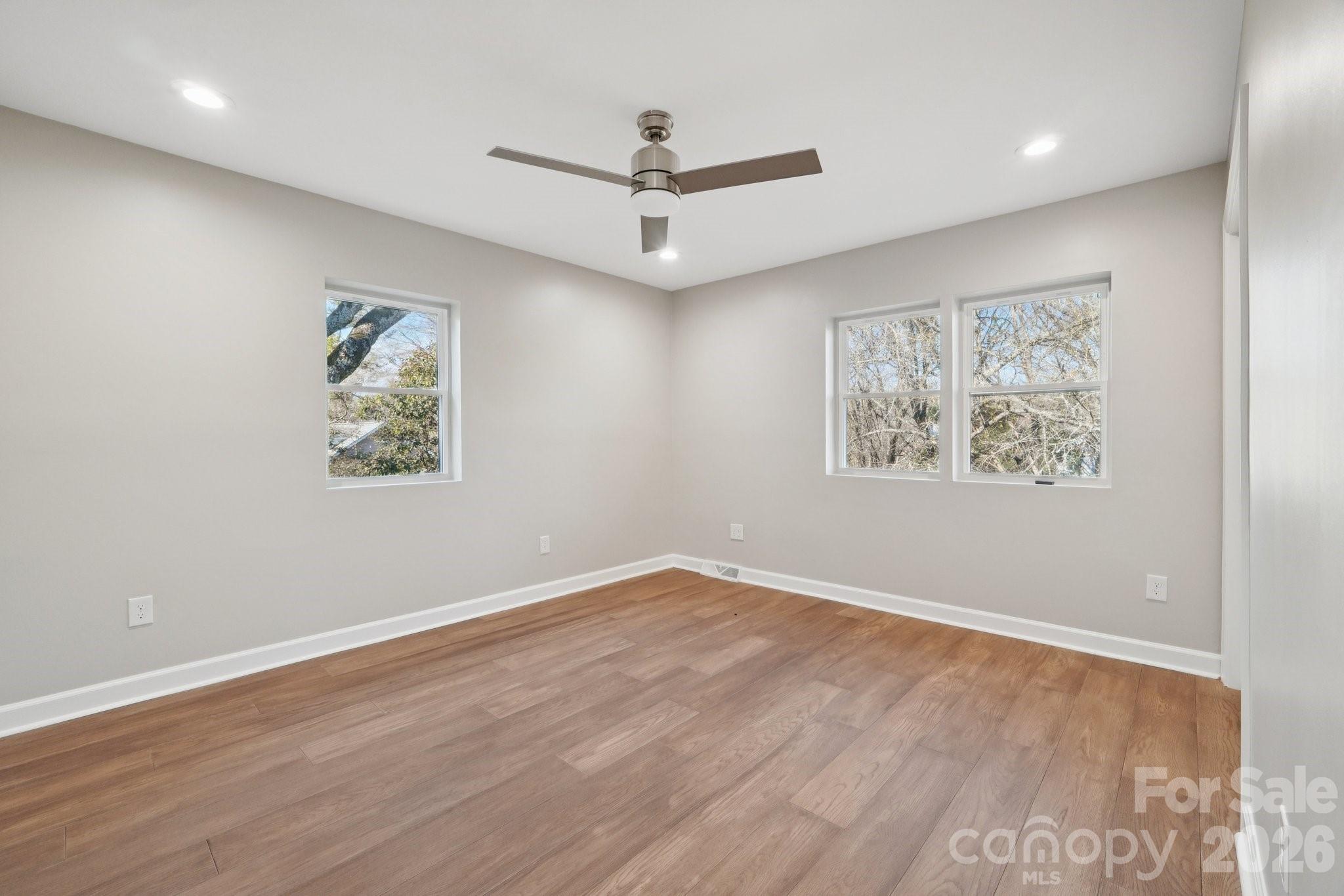 1216 Old Farm Road Charlotte, NC 28226 - Photo 22 of 36 an empty room with wooden floor and ceiling fan
