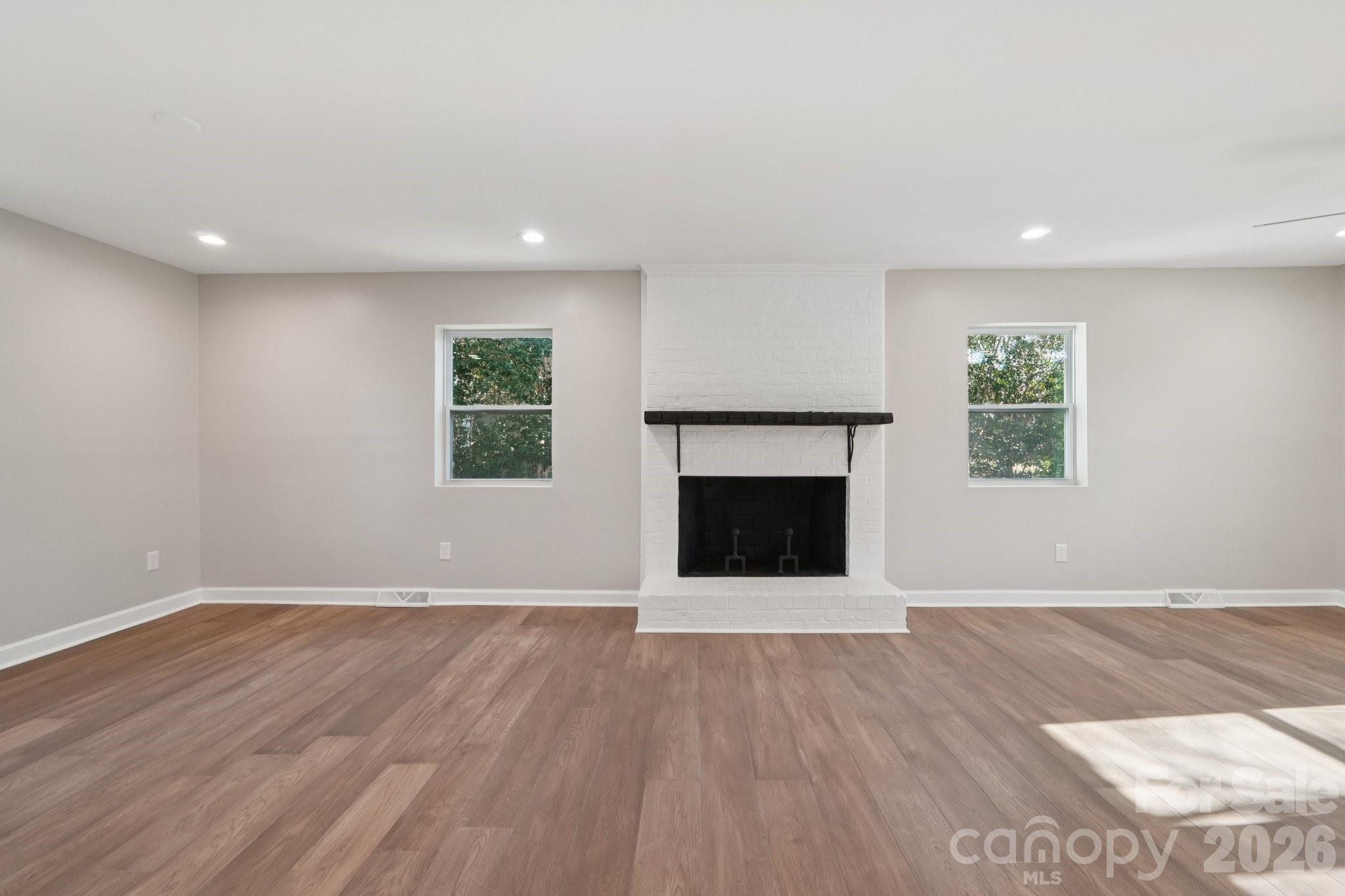 1216 Old Farm Road Charlotte, NC 28226 - Photo 6 of 36 an empty room with wooden floor and a fireplace