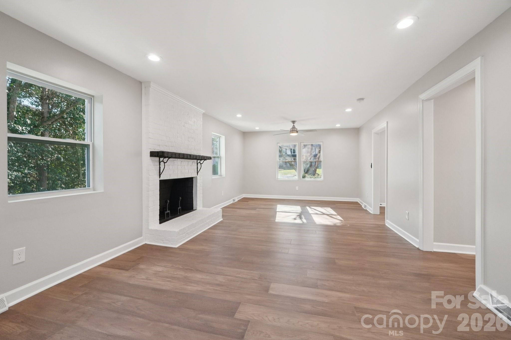 1216 Old Farm Road Charlotte, NC 28226 - Photo 7 of 36 a view of empty room with wooden floor and fireplace