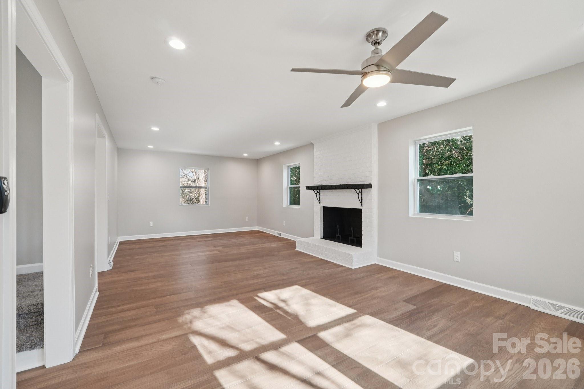1216 Old Farm Road Charlotte, NC 28226 - Photo 8 of 36 an empty room with wooden floor fireplace and windows