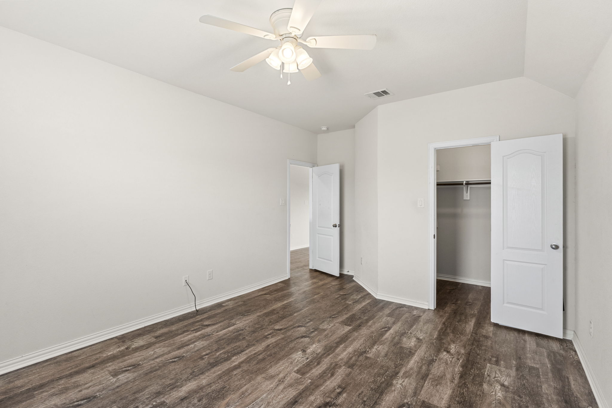 373 Rough Bark Street Buda, TX 78610 - Photo 20 of 39 A well-lit bedroom with LVP flooring and a refreshing ceiling fan offers a comfortable personal retreat.