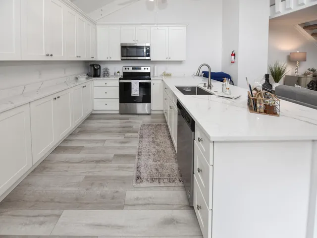 a kitchen with granite countertop a sink and white cabinets