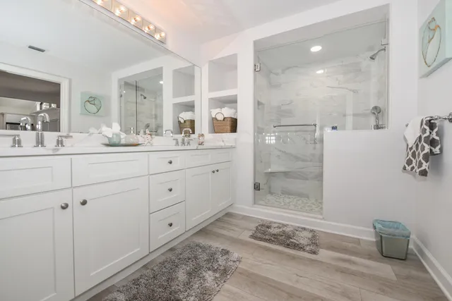 a bathroom with a granite countertop sink mirror and shower