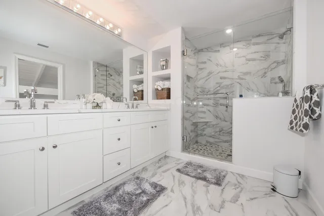 a bathroom with a double vanity sink toilet and shower